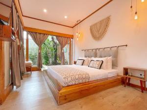 a bedroom with a bed and a large window at Villa Casa Koko in Gili Air