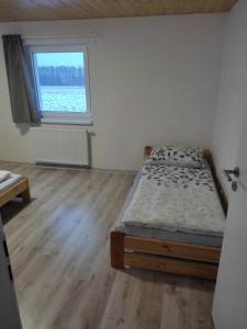 a bedroom with a bed and a window at Apartmány PRO LIPNO in Horní Planá