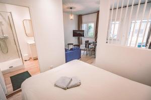 Habitación blanca con cama y espejo en SOCOTRA - Logement Climatisé en Centre-Ville, en Reims