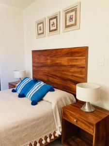 um quarto com uma cama e uma cabeceira em madeira em El Colorín, a condo in the heart of Huatulco em Santa Cruz, Huatulco