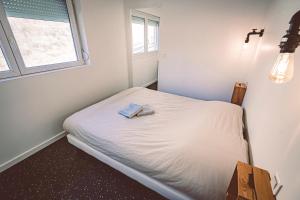 - un petit lit dans une chambre avec fenêtre dans l'établissement Tromsø, à Reims