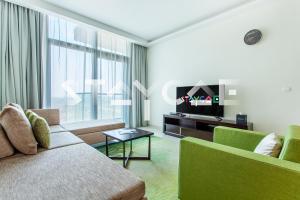 - un salon avec un canapé et une télévision dans l'établissement Staycae Holiday Homes - Celestia, à Dubaï