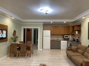 een keuken en een woonkamer met een bank en een tafel bij Alva Sitesi Comfortable apartments by the sea in Alanya
