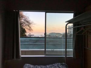 a window in a room with a view of the ocean at ArtBar & GuestHouse ennova in Atami