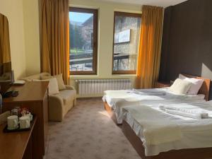 een hotelkamer met 2 bedden en een raam bij Room in Guest room - Apartment StayInn Granat in Bansko - next to Gondola Lift, perfect for 3 guests in Bansko