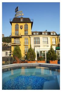 a building with a swimming pool in front of a building at Business Hotel Premier in Veliko Tŭrnovo