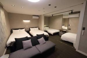 福岡的住宿－White Crystal RoomB，酒店客房,设有两张床和一张沙发