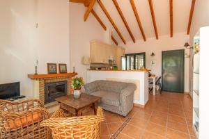 a living room with a couch and a fireplace at Rosas Cantares: Casa Maurus. in Pizarra