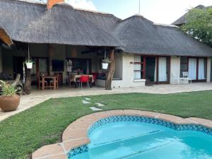 a house with a small swimming pool in the yard at Waterberg INN in Modimolle