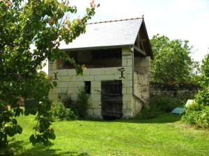 an old stone building with crosses on it in a yard at La Balastière in Beaumont-en-Véron