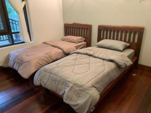 Kampong TengにあるCA Homestay Borneo Highlandのベッド2台が隣同士に設置された部屋です。