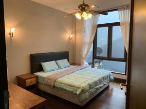 ein Schlafzimmer mit einem Bett und einem großen Fenster in der Unterkunft CA Homestay Borneo Highland in Kampong Teng