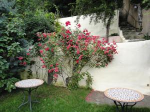 twee tafels in een tuin met roze bloemen bij Dominic Boutique in Sighişoara