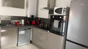 a kitchen with a refrigerator and a microwave at Superbe appartement in Roanne