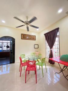uma sala de jantar com uma mesa e cadeiras e uma ventoinha de tecto em Family Homestay em Kuala Terengganu