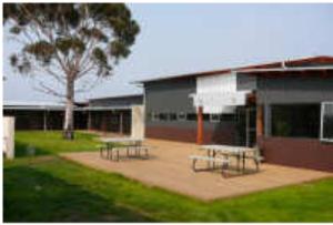 a group of picnic tables in front of a building at Swansea Backpackers in Swansea