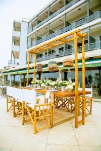 a wooden table and chairs in front of a building at Hotel Panorama in Thessaloniki