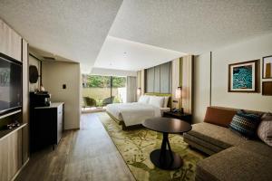 une chambre d'hôtel avec un lit et un canapé dans l'établissement Hotel Indigo Karuizawa, à Karuizawa