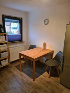 cocina con mesa de madera y 2 sillas en Ferienwohnung Nauwies, en Nohfelden