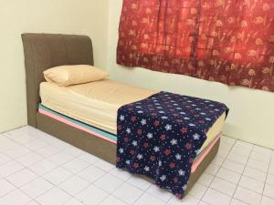 Una cama pequeña en una habitación con ventana. en Taiping Desa Jana Home Stay, en Kamunting 8 fotos más