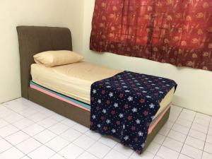 a small bed in a room with a window at Taiping Desa Jana Home Stay in Kamunting