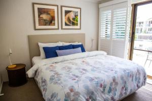 a bedroom with a bed with a floral bedspread at 2 Bedroom Renovated Townhouse, Walk to Noosa River in Noosaville +22 photos