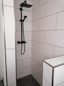een douche met een zwarte douchekop in de badkamer bij Neue Ferienwohnung, Center Park, Bodensee, WAZ in Kißlegg