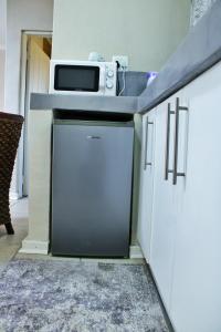 a kitchen with a dishwasher and a microwave at Maruleng Guest House in Hoedspruit