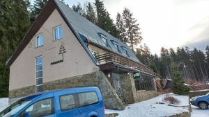 una furgoneta azul estacionada frente a un edificio en Veghouse - Penzion u pláže en Horní Bečva