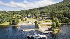 a boat is docked at a dock in the water at Hytte nær vannet, jacuzzi og sauna in Vradal