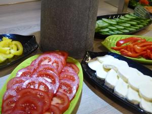 einen Tisch mit Teller mit Speisen mit Tomaten und Käse in der Unterkunft Strand-Hotel in Dangast