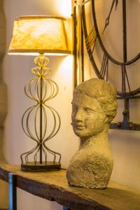 une statue d'une tête assise sur une table à côté d'une lampe dans l'établissement Alacati LuCe Design Hotel - Special Category, à Alaçatı