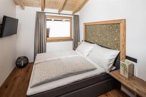 Un dormitorio con una cama grande y una ventana en Bergsuite Pfaffenebner, en Matrei in Osttirol