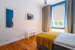 um quarto com uma cama e uma janela em Victus Apartamenty, Apartament Grand em Sopot