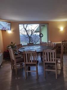 une salle à manger avec une grande table et des chaises en bois dans l'établissement Винарна-Славовица, à Kalugerovo