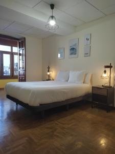 een slaapkamer met een groot bed met witte kussens bij Casa del Beso II in Luarca