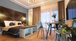 a bedroom with a bed and a table and chairs at DK Premium UkielPark in Olsztyn