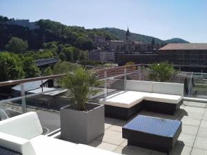 eine Terrasse mit weißen Sofas und Pflanzen auf dem Dach in der Unterkunft Appart'Hôtel Luxapparts in Besançon