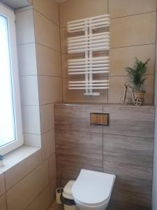 a bathroom with a toilet and a window at Dom Gościnny Asia in Kołobrzeg