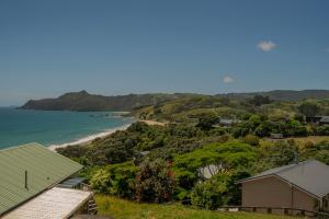 a view of a beach with houses and the ocean at Hosts on the Coast Ātaahua. in Kuaotunu