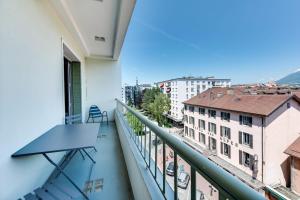 a balcony with a table and a view of a city at Allure - 2 bedroom apartment with balcony in the centre of Annecy in Annecy