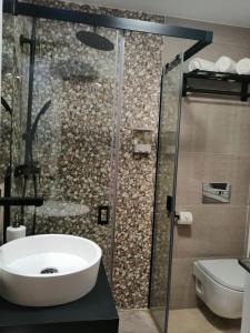 y baño con lavabo y ducha. en ÁTICO EXCLUSIVO EN EL CENTRO DE GRANADA, en Granada