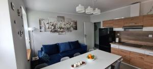 salon z niebieską kanapą i stołem w obiekcie Apartamenty Promyk Wisełka w Wisełce
