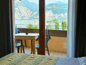 a bedroom with a view of the ocean from a balcony at Hotel Villa Isabella in Brenzone sul Garda