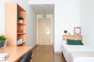 a bedroom with a desk and a bed and a table at Residencia Universitaria Sant Jordi in Tarragona