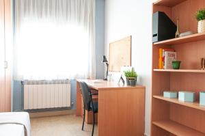 a room with a desk with a bed and a window at Residencia Universitaria Sant Jordi in Tarragona