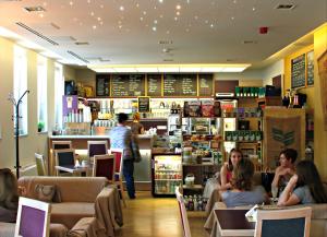 a restaurant with people sitting in chairs and a bar at Szent Gellért Hostel in Székesfehérvár