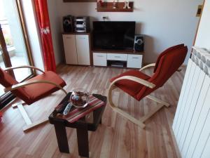 a living room with two chairs and a table and a television at Apartments Novak in Rovinj