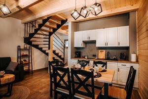 a kitchen and dining room with a table and a staircase at Holickie Berdo in Polańczyk
