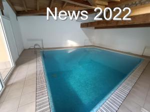a swimming pool in a building with the words news at Hotel Villa Isabella in Brenzone sul Garda